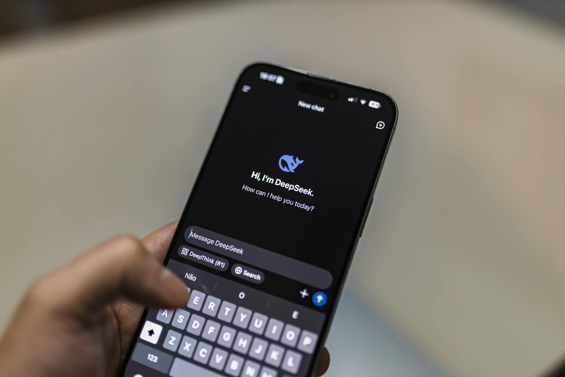 Smartfon z ekranem czatu AI trzymany w dłoni
