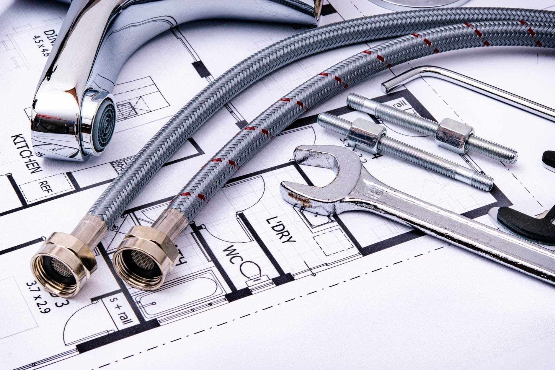 Narzędzia hydrauliczne i bateria leżące na planie instalacji wodnej