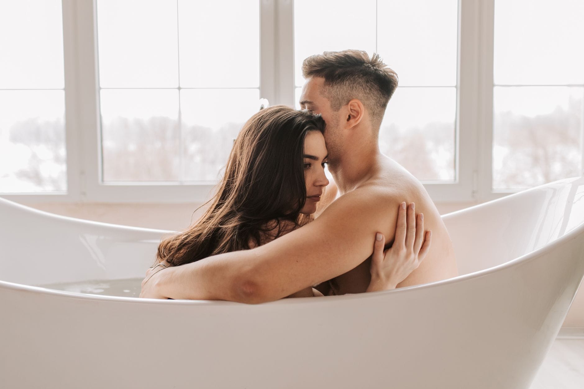 Para relaksująca się razem w nowoczesnej wannie podczas domowego SPA